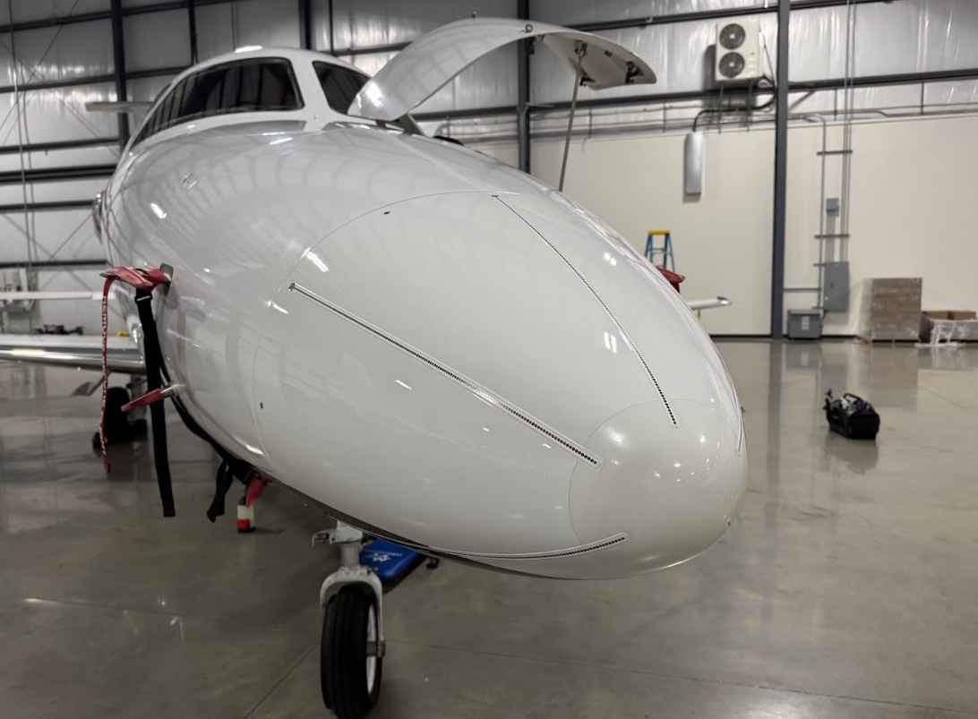 Gleaming nose of a private jet after exterior cleaning in the hangar